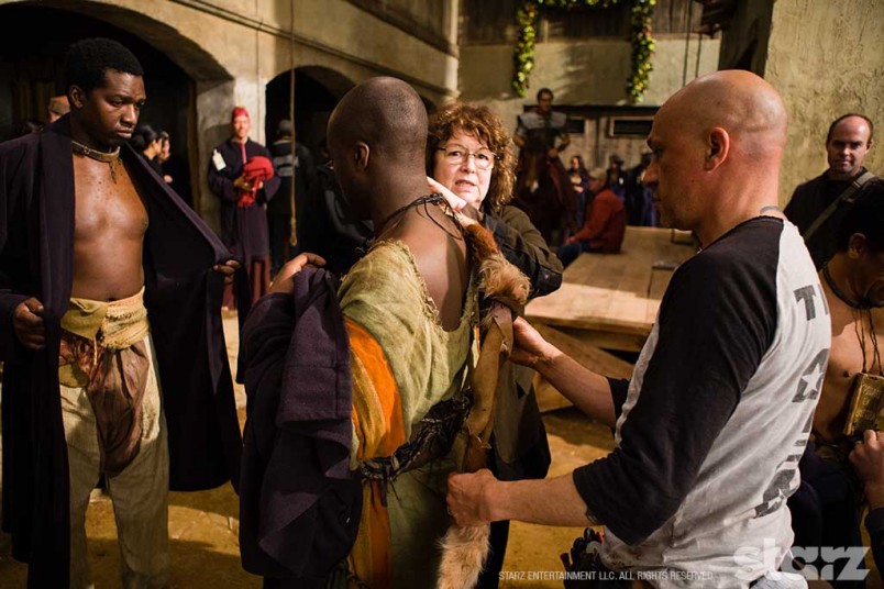 Costume Designer Barbara Darragh adjusts a costume on set